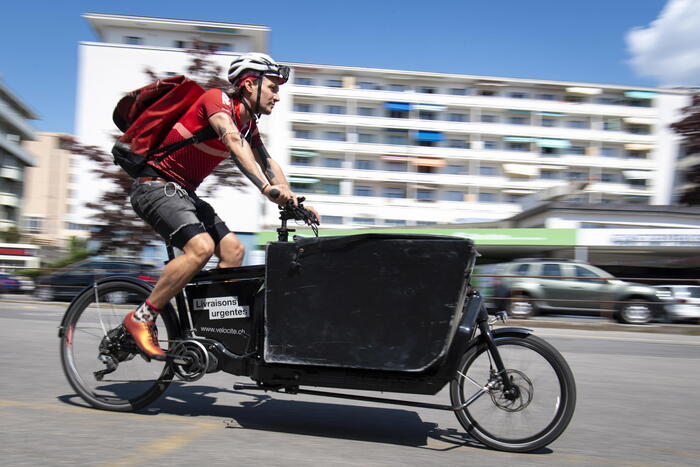 epa08383572 Jean-Sebastien Luy, co-director and courier of velocite delivery company, rides a cargo bicycle to bring food to people in lockdown during the state of emergency put in place because of the of the coronavirus and COVID-19 disease pandemic, in Lausanne, Switzerland, 24 April 2020 (issued 25 April 2020). Countries around the world are taking increased measures to stem the widespread of the SARS-CoV-2 coronavirus which causes the COVID-19 disease. EPA/LAURENT GILLIERON